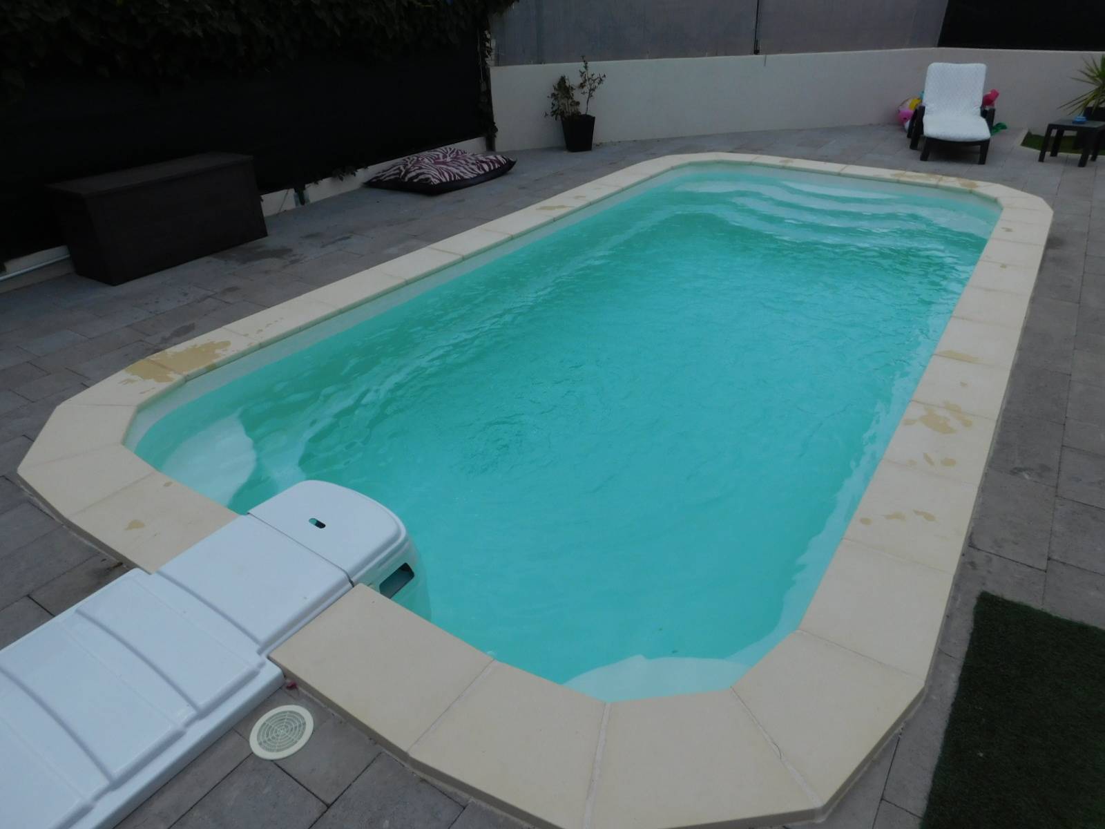 DÉCLIC R600 BF : Piscine coque polyester avec bloc filtrant compact, un escalier et une banquette