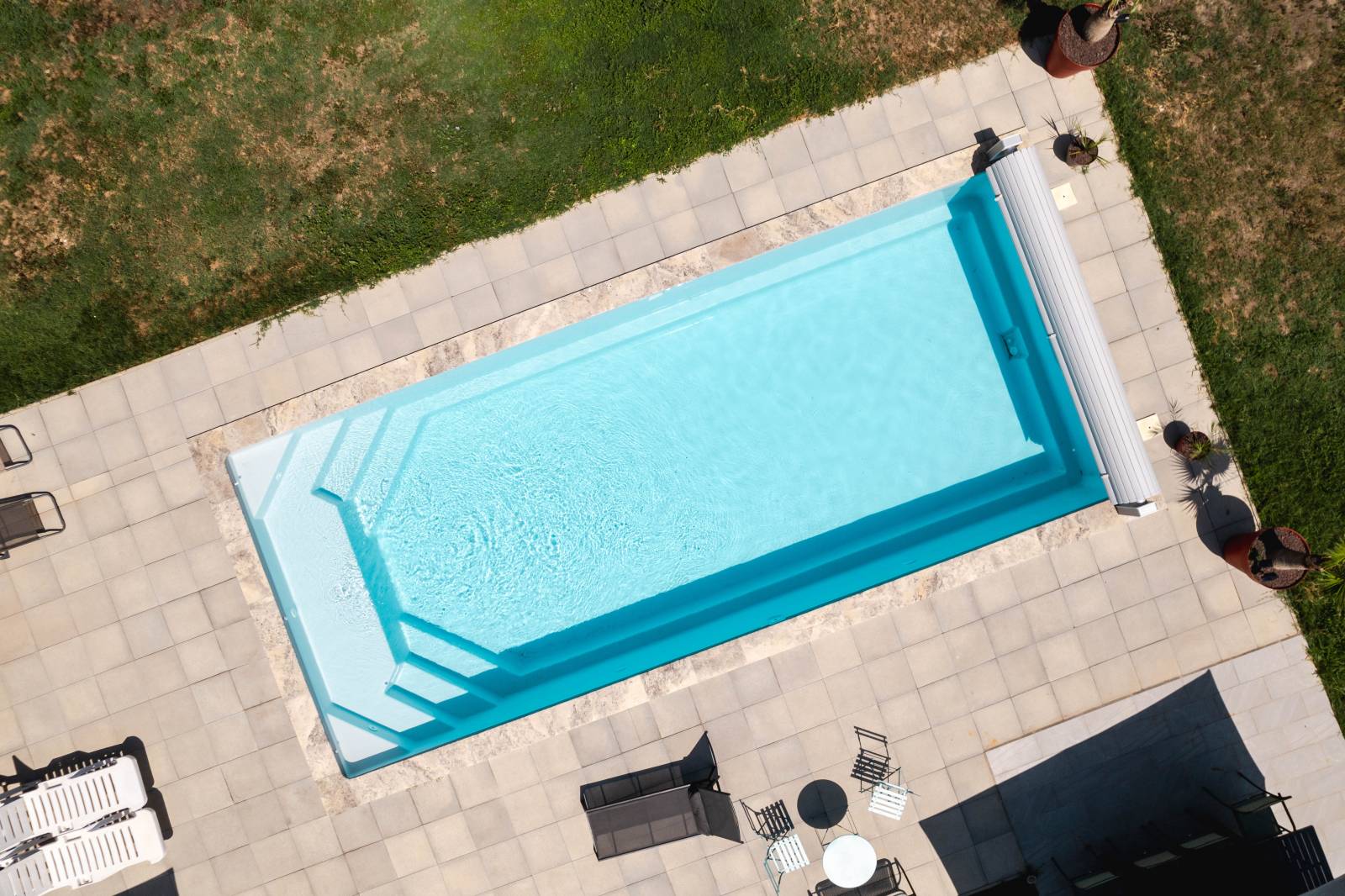 MANUA : Piscine coque polyester avec des escaliers d'angles et une large banquette