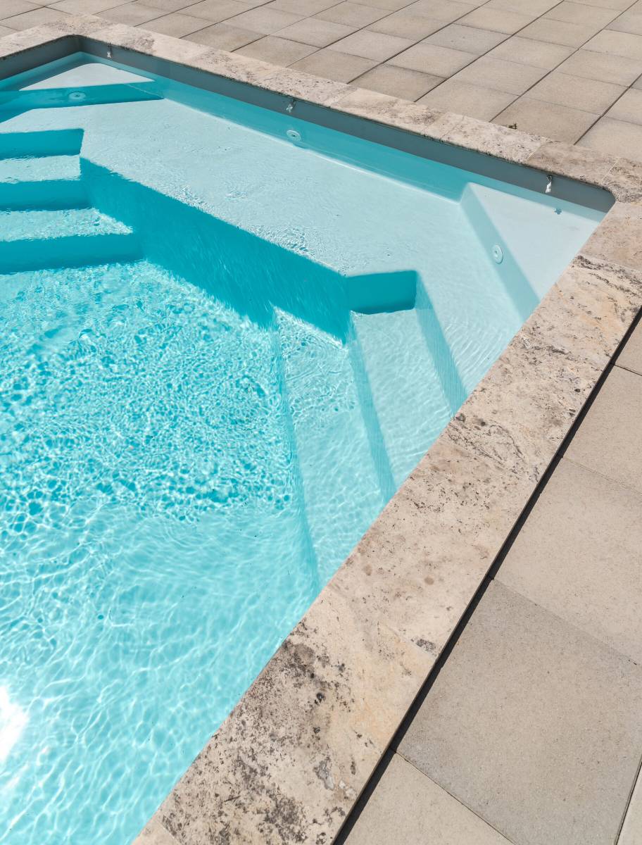 Installation d'une piscine coque modèle MANUA avec volet automatique hors sol à Nîmes dans le Gard, de couleur blanche.