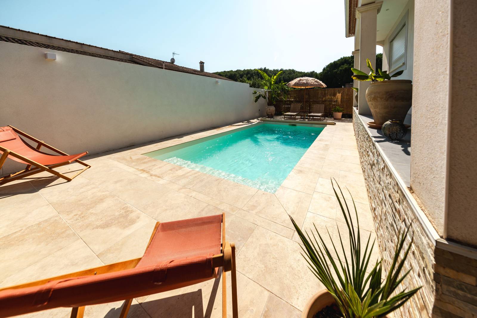 Pose d'une piscine coque polyester modèle MAKENA à Beauvoisin à coté de Vauvert de couleur Ivoire avec margelles en travertin beige