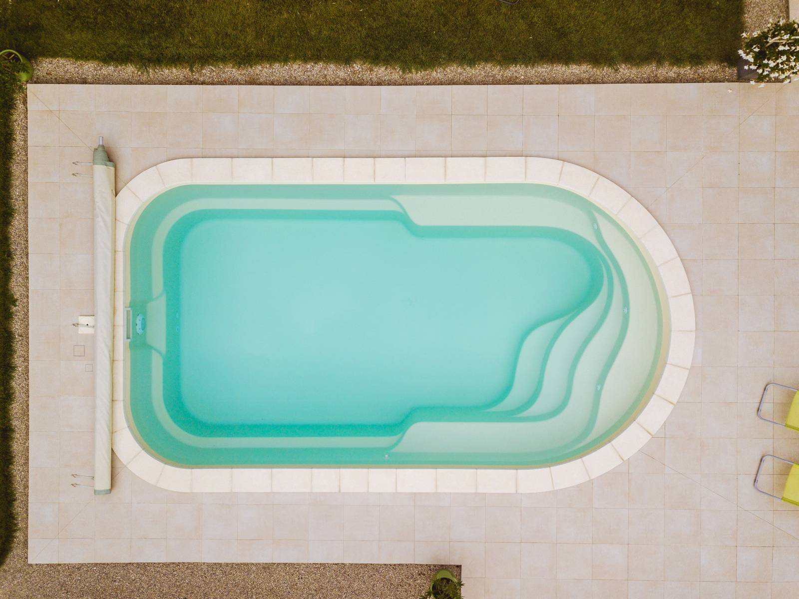 CUBA : Piscine coque polyester de forme arrondie avec un grand escalier et deux banquettes