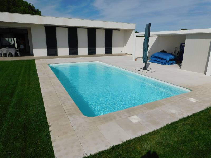 FÉROÉ : Piscine coque polyester avec un large escalier d'angle et une banquette