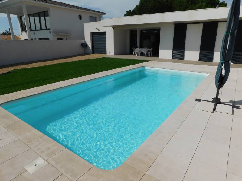 FÉROÉ : Piscine coque polyester avec un large escalier d'angle et une banquette