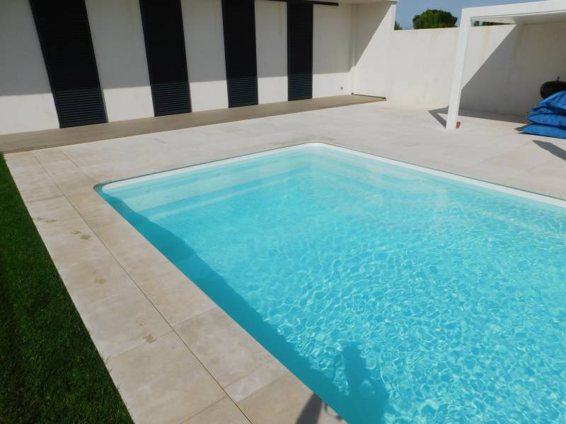 FÉROÉ : Piscine coque polyester avec un large escalier d'angle et une banquette