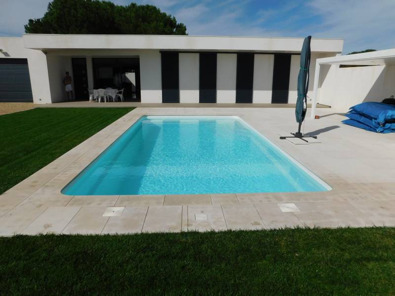 FÉROÉ : Piscine coque polyester avec un large escalier d'angle et une banquette