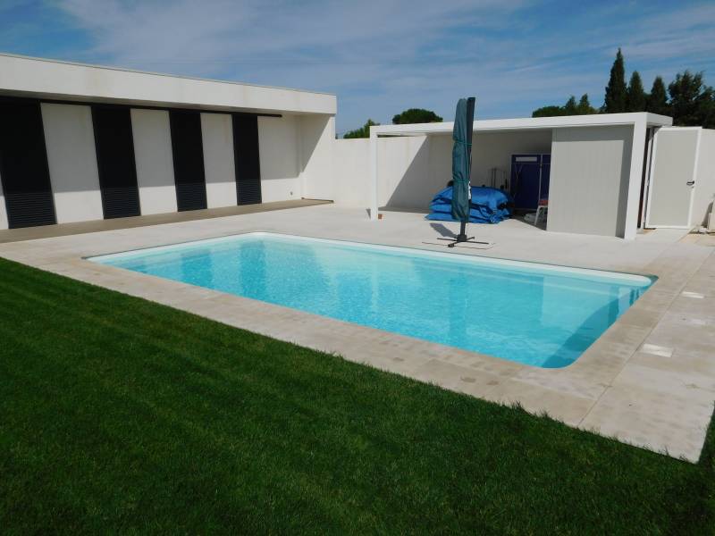 FÉROÉ : Piscine coque polyester avec un large escalier d'angle et une banquette