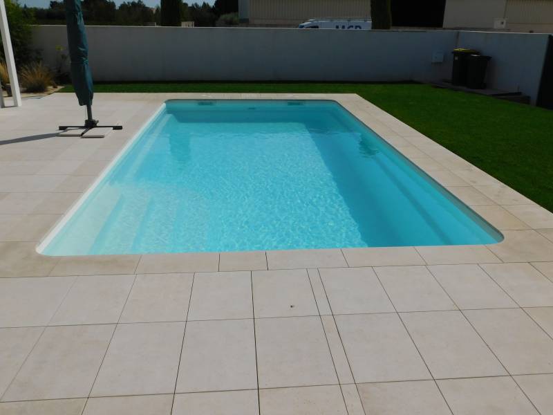 FÉROÉ : Piscine coque polyester avec un large escalier d'angle et une banquette