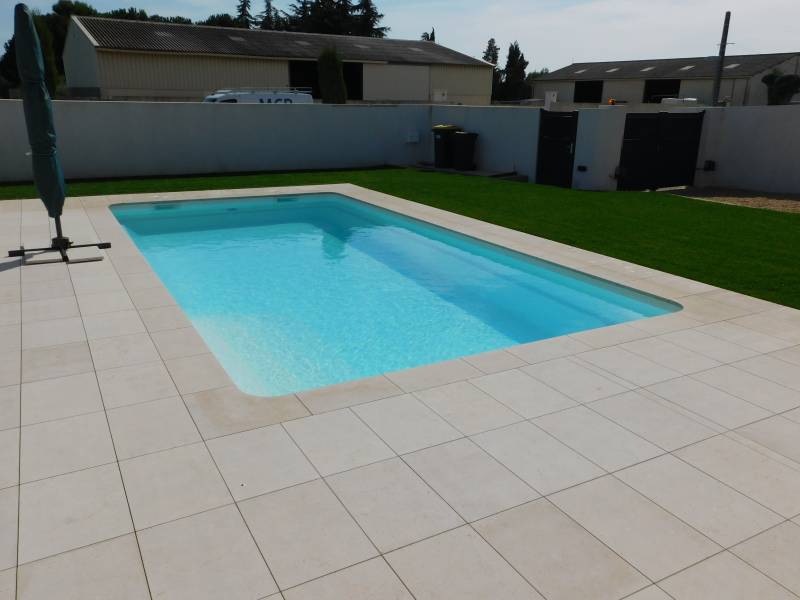 FÉROÉ : Piscine coque polyester avec un large escalier d'angle et une banquette