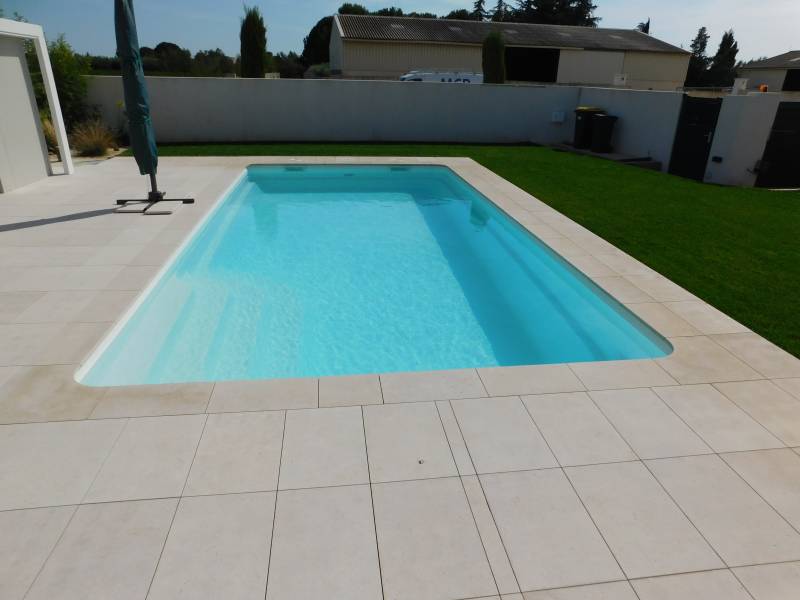 FÉROÉ : Piscine coque polyester avec un large escalier d'angle et une banquette