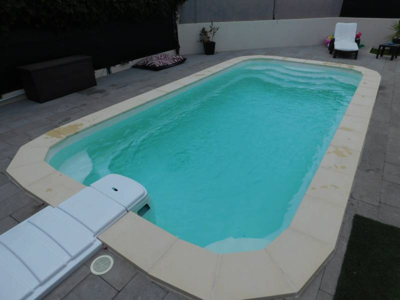 DÉCLIC R600 : Piscine coque polyester avec bloc filtrant compact, un escalier et une banquette