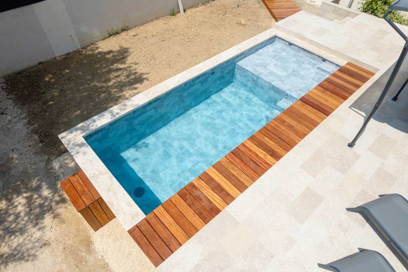 Piscine traditionnelle en PVC Armé imitation pierre de Bali avec une très grande plage