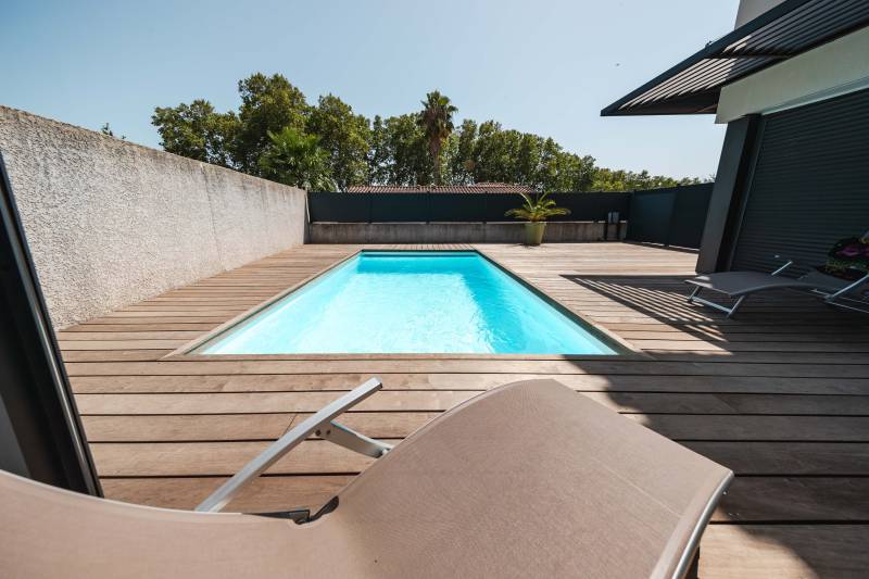 Piscine traditionnelle avec couverture automatique immergée.