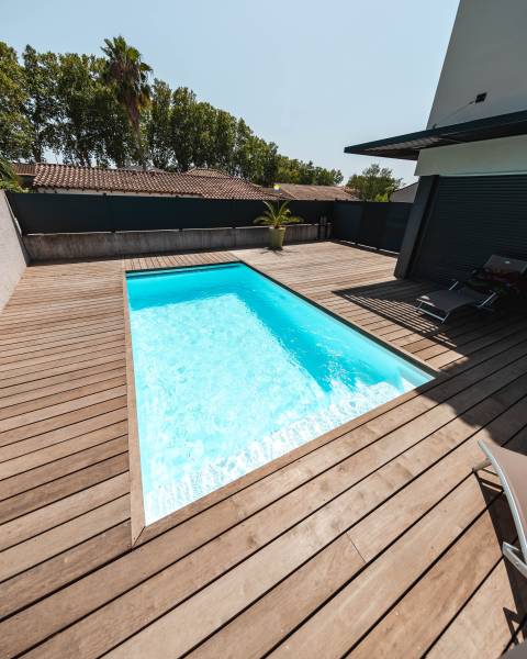 Piscine traditionnelle avec couverture automatique immergée.