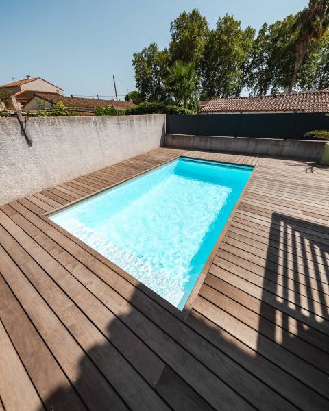 Piscine traditionnelle avec couverture automatique immergée.