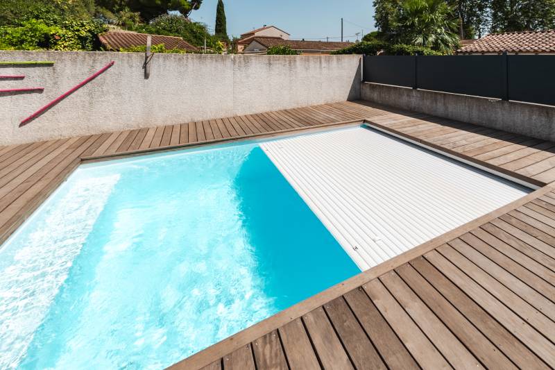 Piscine traditionnelle avec couverture automatique immergée.