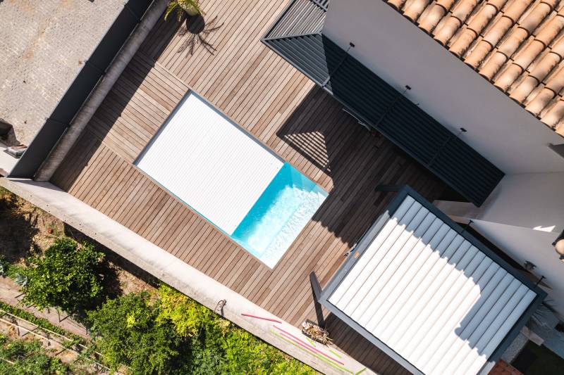 Piscine traditionnelle avec couverture automatique immergée.