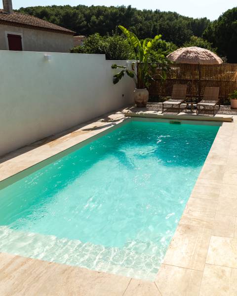 MAKENA : Piscine coque polyester avec un escalier d'angle et une grande plage