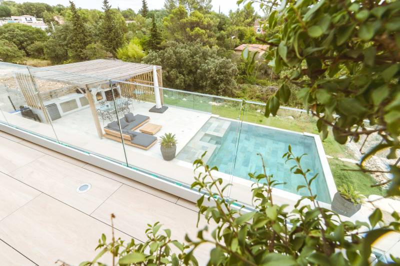 Piscine traditionnelle avec débordement et revêtement en carrelage de Bali