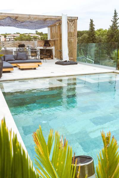 Piscine traditionnelle avec débordement et revêtement en carrelage de Bali