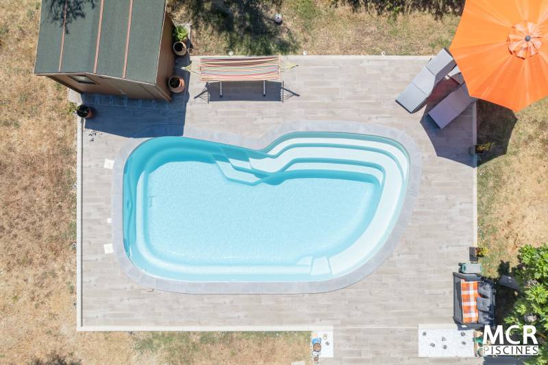 UVEA : Piscine coque polyester de forme ovale avec un large escalier arrondie