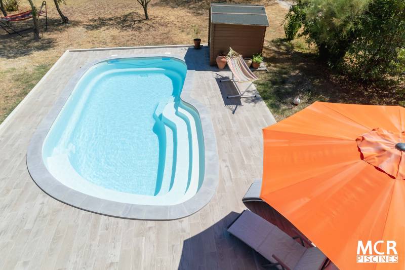 UVEA : Piscine coque polyester de forme ovale avec un large escalier arrondie