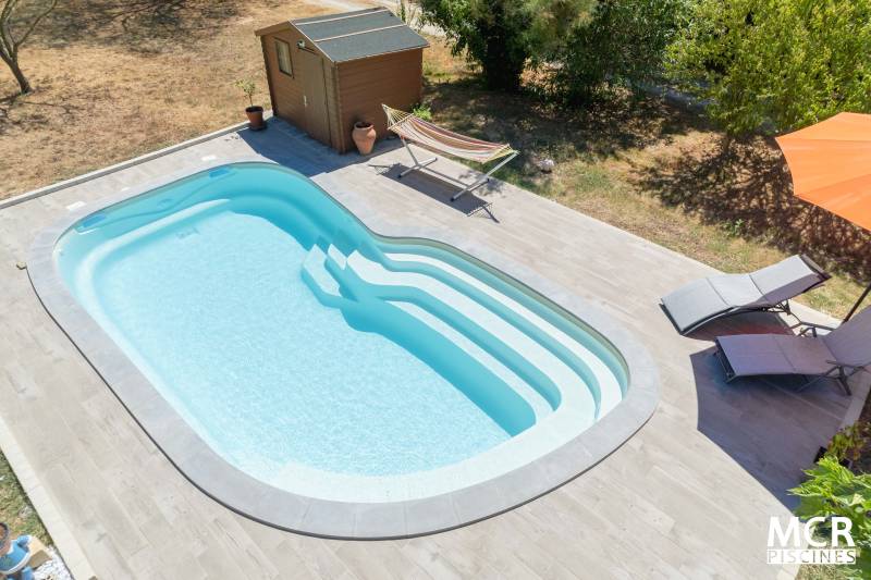 UVEA : Piscine coque polyester de forme ovale avec un large escalier arrondie