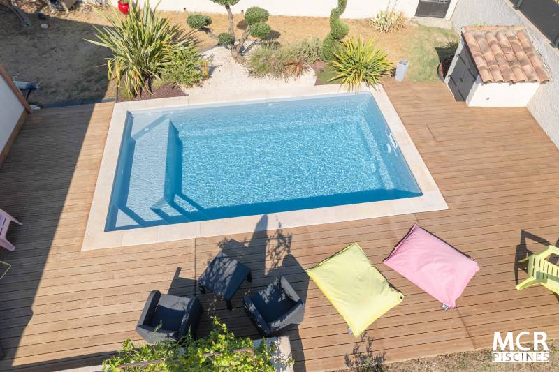 MANURÉVA : Piscine coque polyester avec une banquette et un escalier d'angle