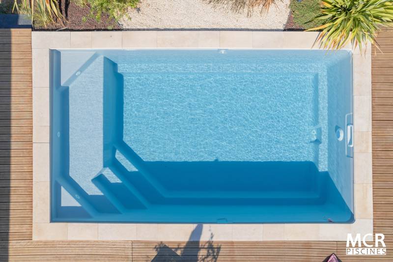 MANURÉVA : Piscine coque polyester avec une banquette et un escalier d'angle