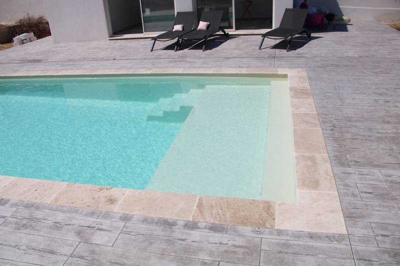 Livraison et installation d'une piscine coque modèle NOUMÉA à Beauvoisin à côté de Vauvert avec plage de couleur beige.