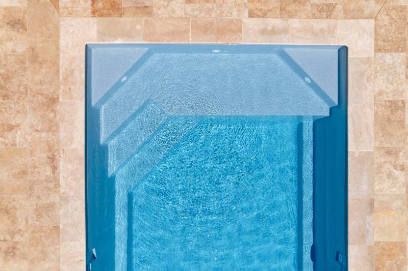 MANURÉVA : Piscine coque polyester avec une banquette et un escalier d'angle